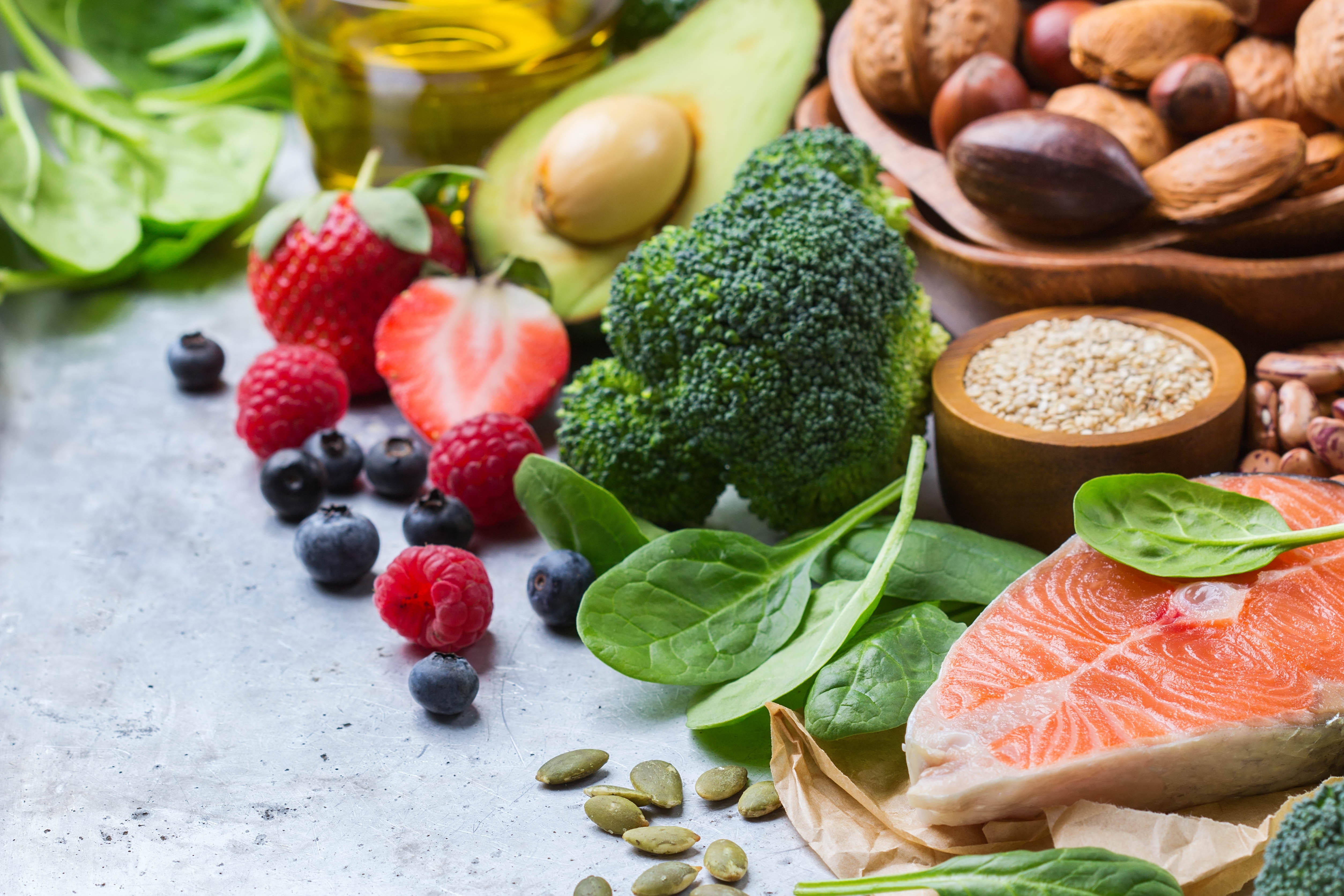 Healthy foods including salmon, spinach, nuts, fruit, seeds, and more